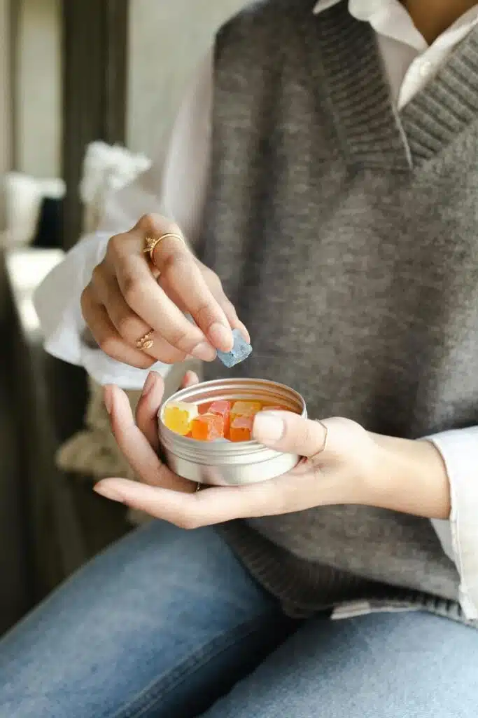 Woman reaching for cannabis gummies in tin